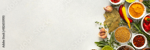 A mix of dried herbs and spices laid out on a gray background, highlighting natural flavors and culinary essentials, top view and copy space, banner