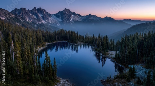 Twilight over rugged Cascade peaks: quiet forest, glassy lake, and pink horizon