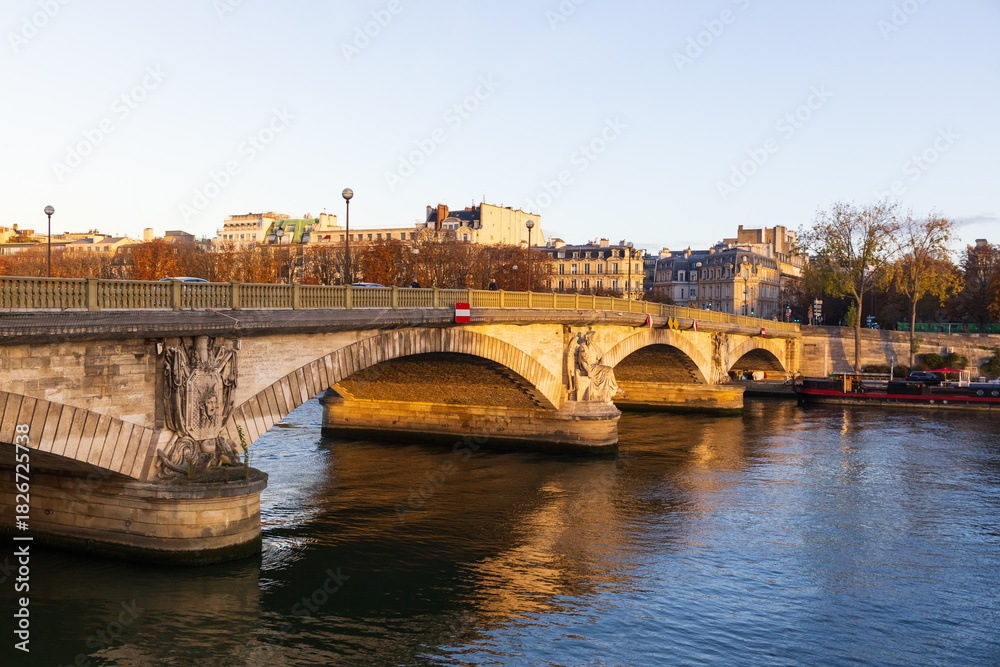 Naklejka premium The 1855 Pont des Invalides, an arch bridge over the Seine in the 7th arrondissement, seen during a golden hour morning, Paris, France