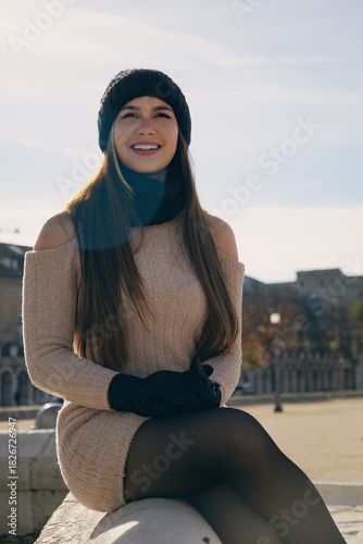 Fotografie Mujer joven con sonrisa natural y alegre en una mañana soleada de invierno en una plaza europea