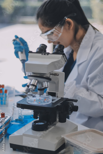 Portrait, science and happy woman on laptop in lab to research chemistry, test or innovation. Microscope, scientist and face of medical doctor in goggles for microbiology, healthcare or pharma study