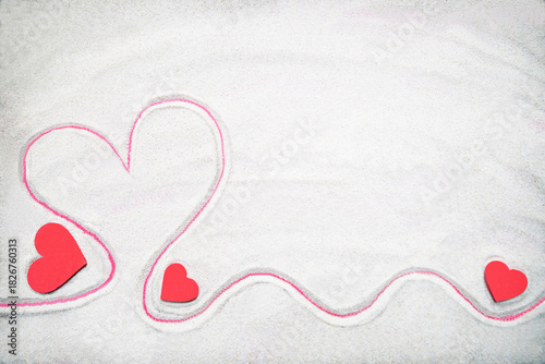 Creative sand texture with three wooden red heart (big and small) and heart drawing on the sand. Valentine's day and love background. Empty place (pattern) for your message. Flat lay. Mockup.