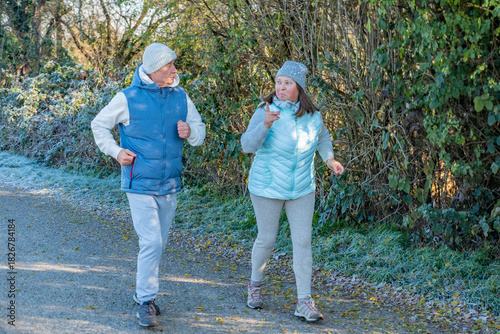 happy senior couple jogging on frosty path, cool weather, morning jog, active lifestyle, healthy enjoying active aging together sports, fitness during, healthier routine in nature, daily exercise