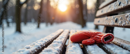 Forgotten child's mitten with a snowflake on it, lying on a park bench  