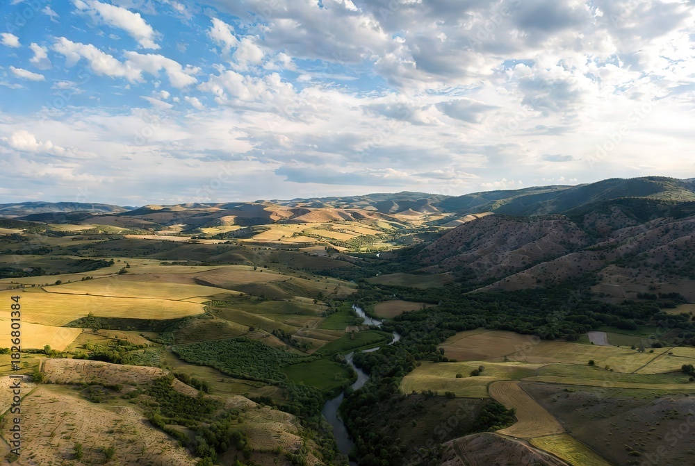 Naklejka premium Rural landscape with winding river and rolling hills, blue sky