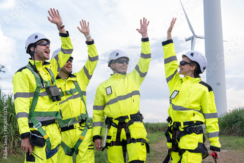 Foto Workers celebrate teamwork and success at a wind farm during a sunny afternoon i