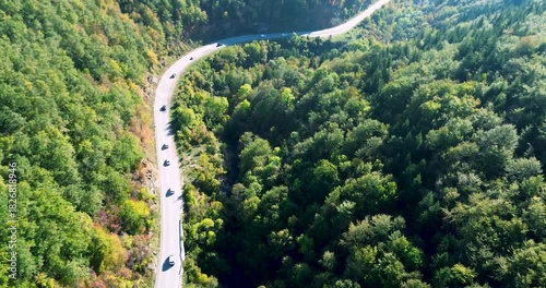 Aerial view of cars convoy driving on mountain road