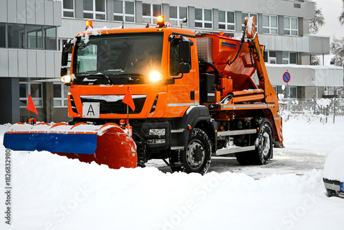 Snowplow truck plowing road, removing snow during winter weather
