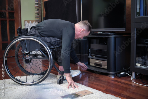 A man in a wheelchair leaned over and prepared to turn on a CD player.