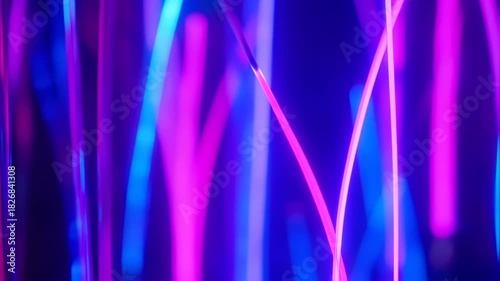 Abstract image of flowing, colored light strands against a deep blue background