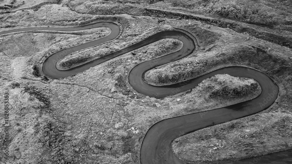 Obraz premium Aerial black and white view of a winding mountain road