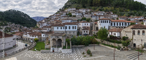 Fotografi Scenic view of Berat’s hillside homes and historic stone architecture rising above the old town square under cloudy skies