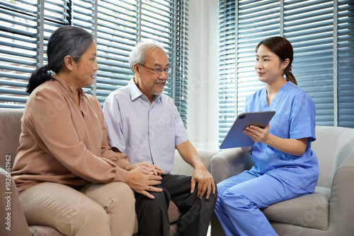 nurse or caregiver meeting and talking with about health with senior couple