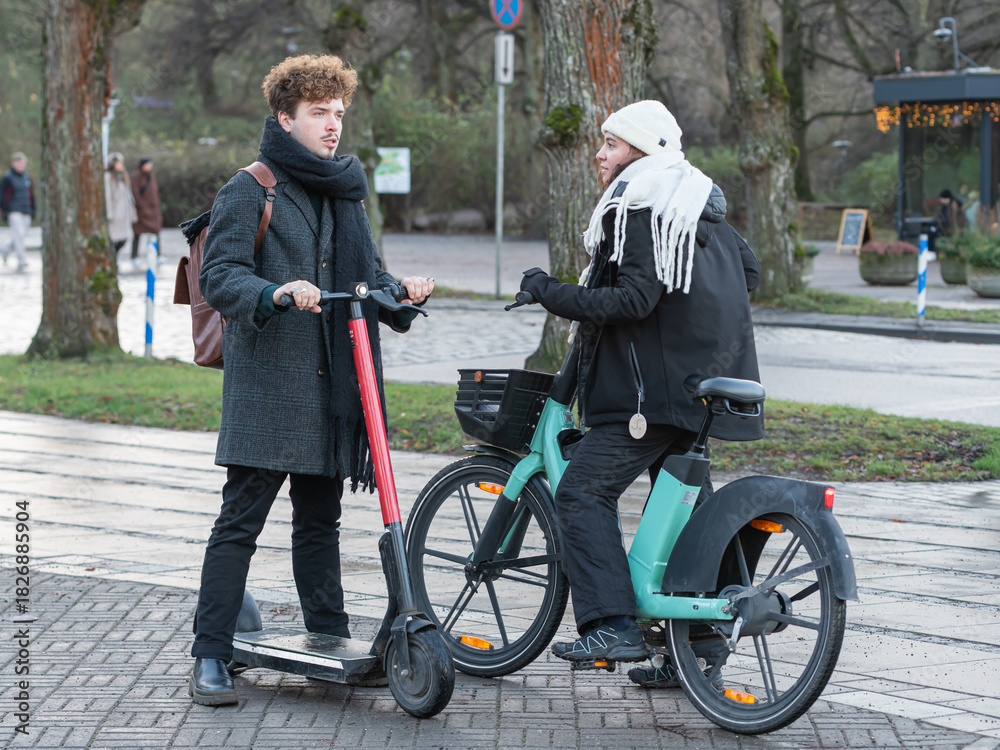 Fototapeta premium Man on a scooter meeting a woman on a bike