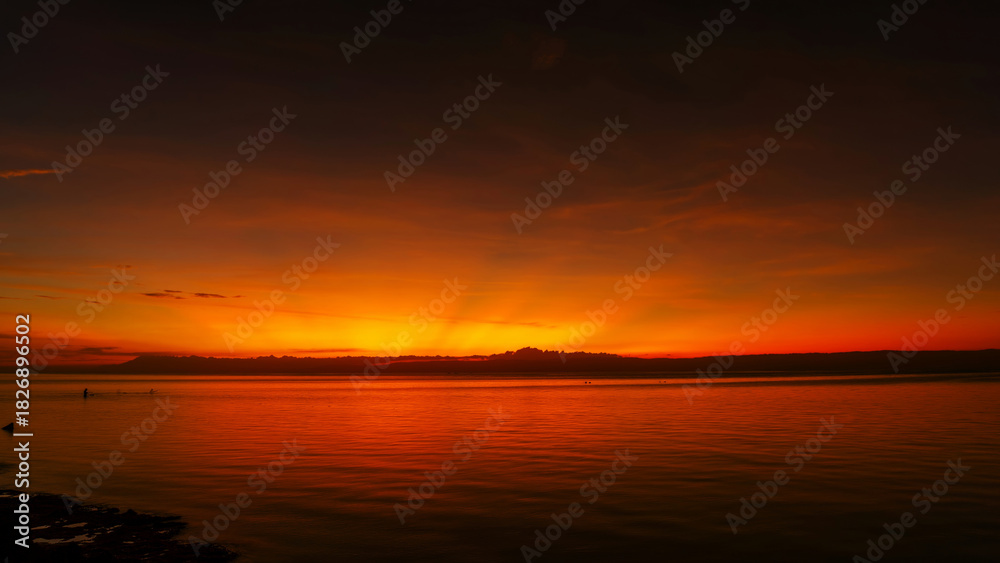 Naklejka premium Stunning sunset over calm ocean waters