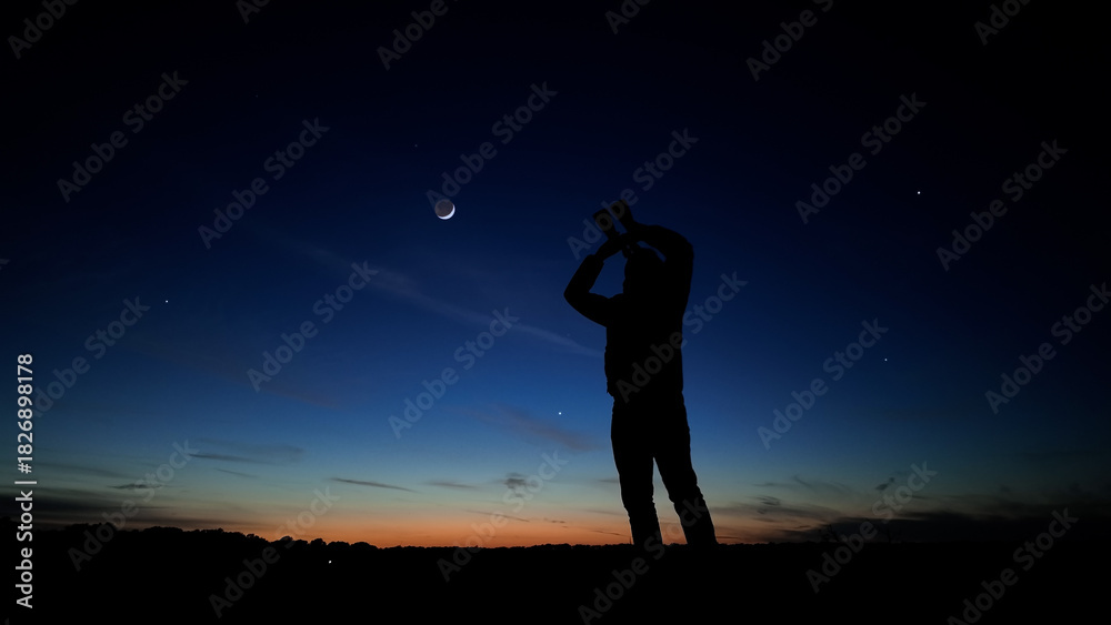 Fototapeta premium Amateur astronomer using binoculars for observing stars, planets, Moon and other celestial objects.