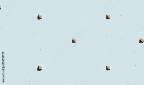 Padrão minimalista de sementes ou pedras marrons sobre fundo azul claro com textura sutil.