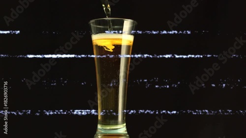 Pouring stream from above starting glass filling, foam forming and bubbles rising to show fizzing