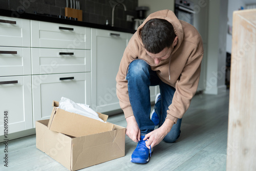 A man tries on sneakers just delivered by mail, experiencing the convenience of fast online shopping and efficient delivery services.