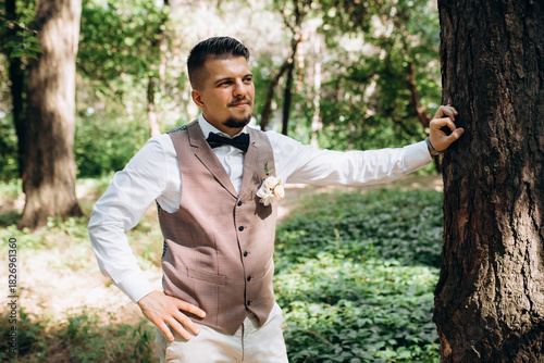 bald guy in a gray jacket on a background of tree