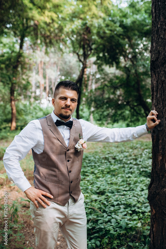 bald guy in a gray jacket on a background of tree