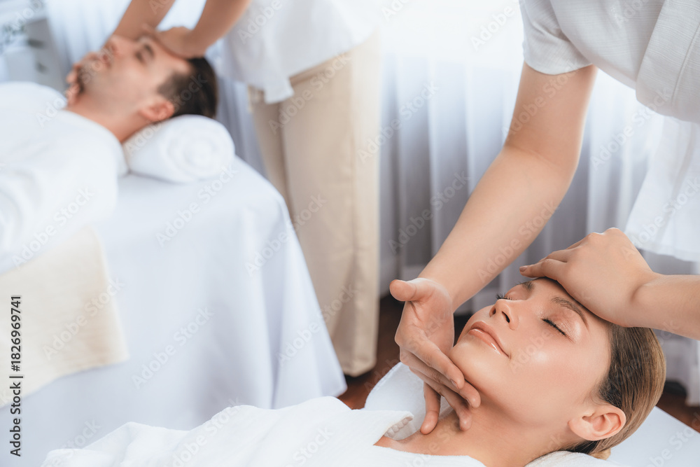 Obraz premium Caucasian couple enjoying relaxing anti-stress head massage and pampering facial beauty skin recreation leisure in dayspa modern light ambient at luxury resort or hotel spa salon. Quiescent