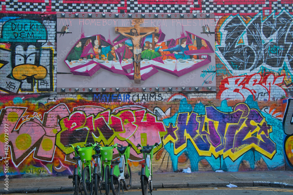 Naklejka premium Murales colorati in strada con biciclette