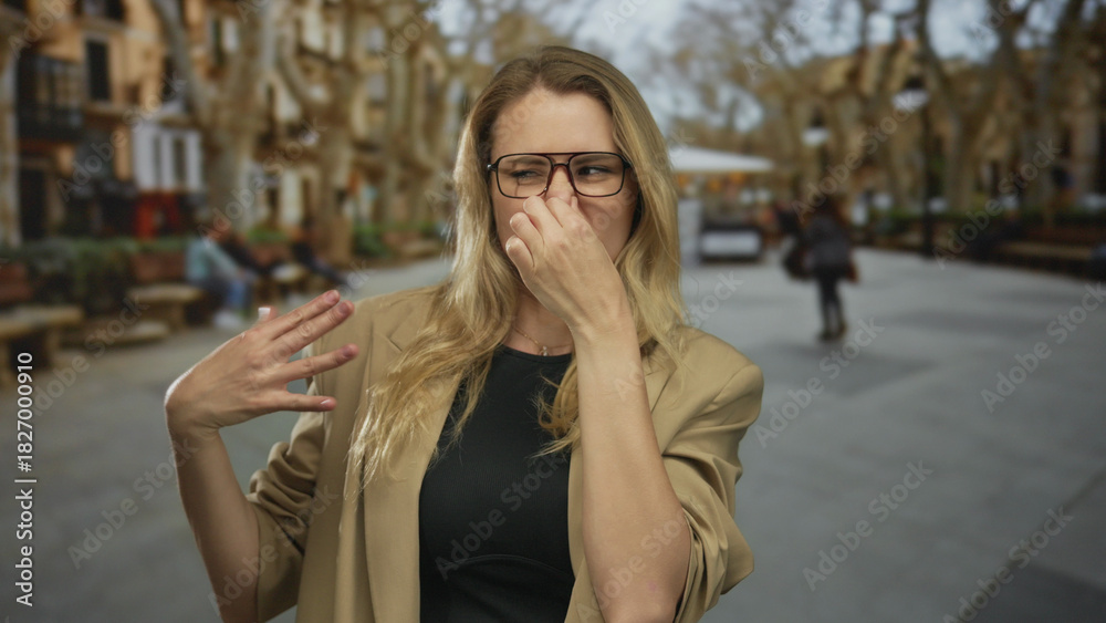 Fototapeta premium Woman pinching nose because of bad smell at street surrounded by urban scenery blending discomfort with curiosity.
