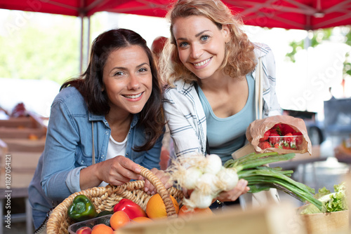 two young diverse women smiling at the market
