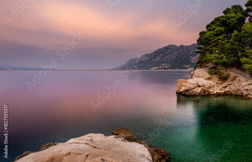 Fototapeta Naklejka Na Ścianę i Meble -  Croatia, Dalmatia, the Adriatic coast at sunrise, with the Biokovo Mountains and forests in the background. The village of Brela is a summer resort on the Makarska Riviera.