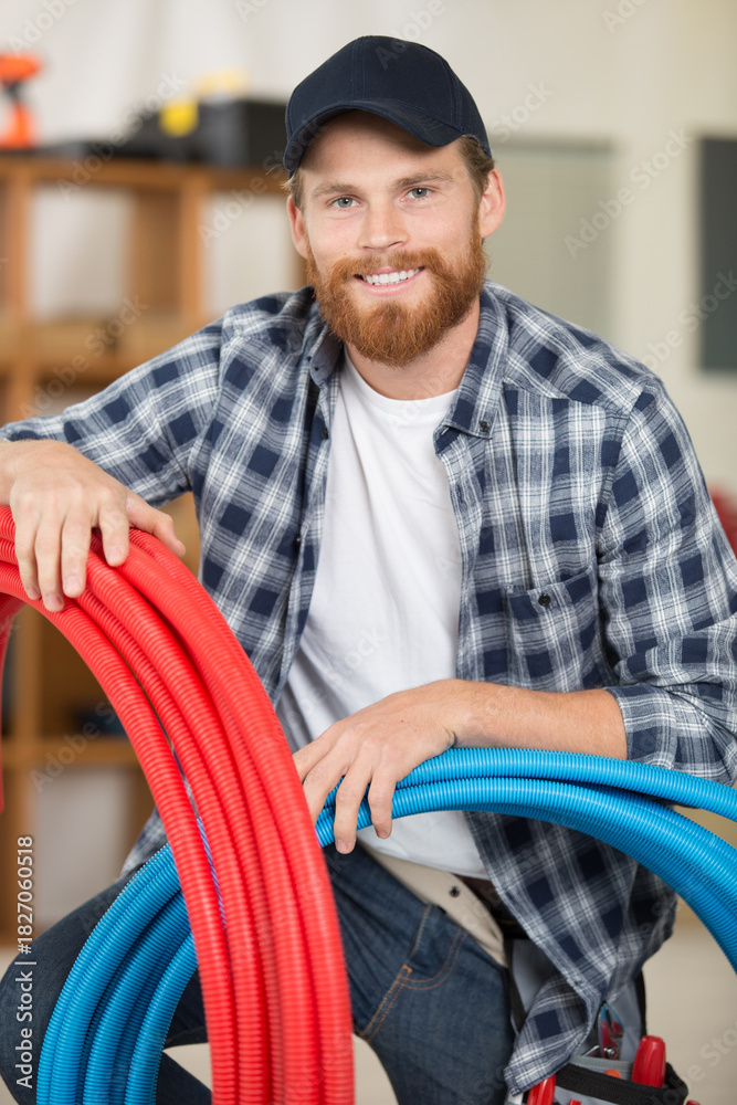 Naklejka premium technician holding water pipes indoors