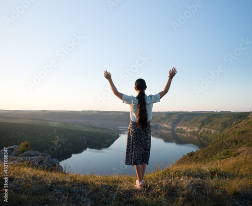 Young alone sad teen lady stand rock ask beg Lord Jesus Christ help win life light sun text space Lone mental forgiv devot faith free arm up bless calm sunny heaven bible church hill field garden park