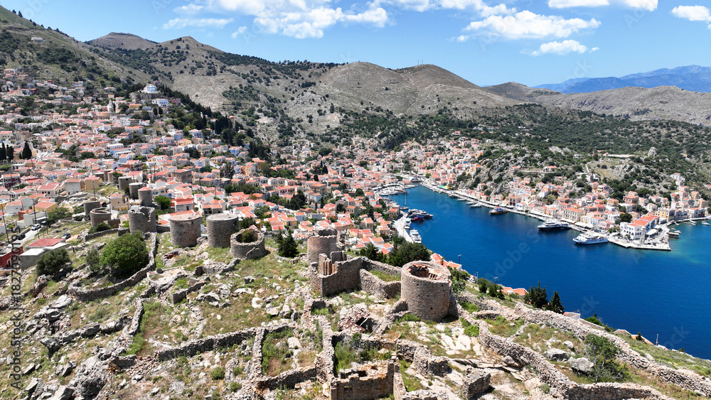 Naklejka premium Aerial drone photo of picturesque old windmills in Ano Symi overlooking main town and Yalos, Symi island, Dodecanese, Greece