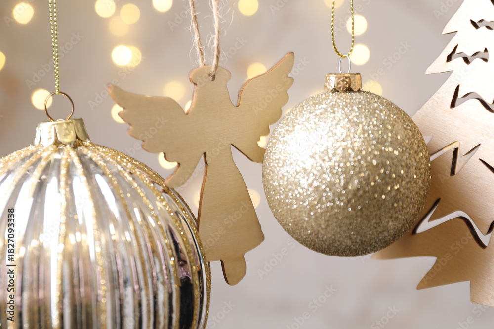 Fototapeta premium Beautiful Christmas decor hanging on string against blurred lights, closeup