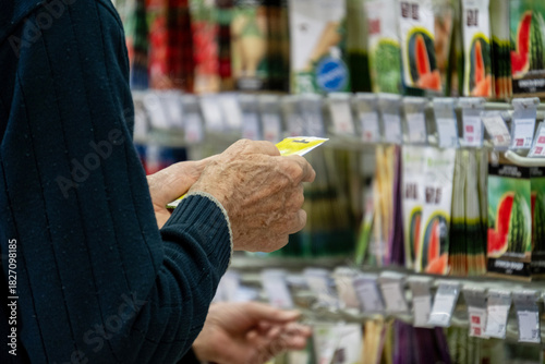 lderly Hands Examining Seed Packets in Garden Store