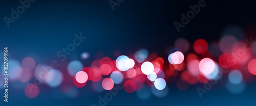 Abstract blurred bokeh lights in red and white on dark blue background creating festive and dreamy atmosphere with soft glowing circles