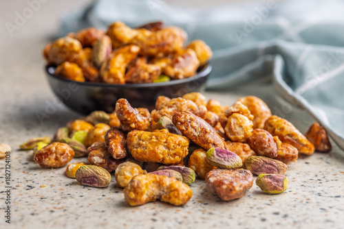 Nuts coated in sugar glaze on kitchen table.