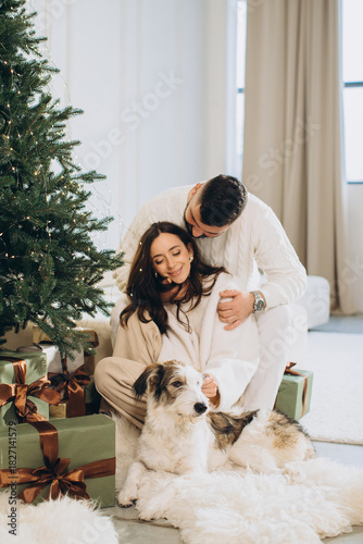 Couple celebrating christmas with pet dog at home