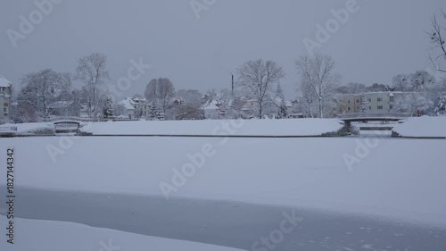 A serene winter landscape with a snowcovered river and tall trees, evoking tranquility and natural beauty
