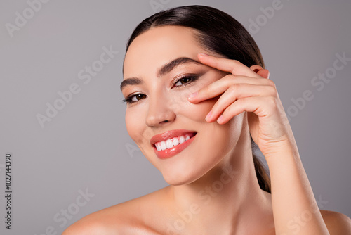 Close up of a beautiful young woman with glowing skin and confident expression, highlighting natural beauty