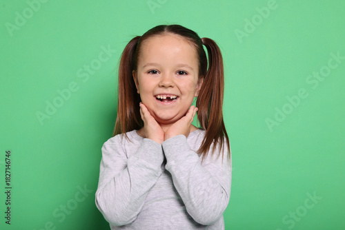 Fényképezés Portrait of cute little girl on green background