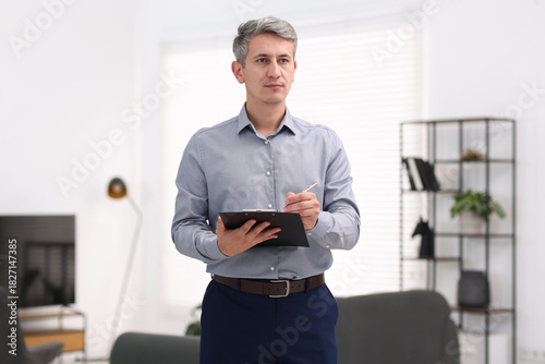 Real estate appraisal. Inspector with clipboard conducting property valuation at home