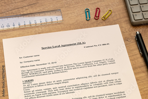 The dummy document of the Service Level Agreement is on the desk, along with a calculator and a pen.