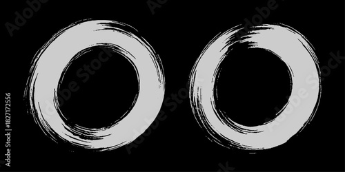 Two bold black ink circles painted with dynamic brush strokes, minimalist Japanese sumi-e style, clean background.