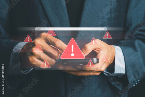 System warning alert on a virtual interface with hand interaction, showing cybersecurity risks, data breaches, malware threats, hacking attempts, and digital system vulnerability in modern technology.