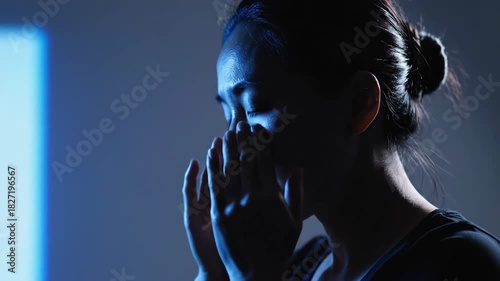 Young Woman Exercising in Dimly Lit Room with Focused Expression and Soft Side Lighting