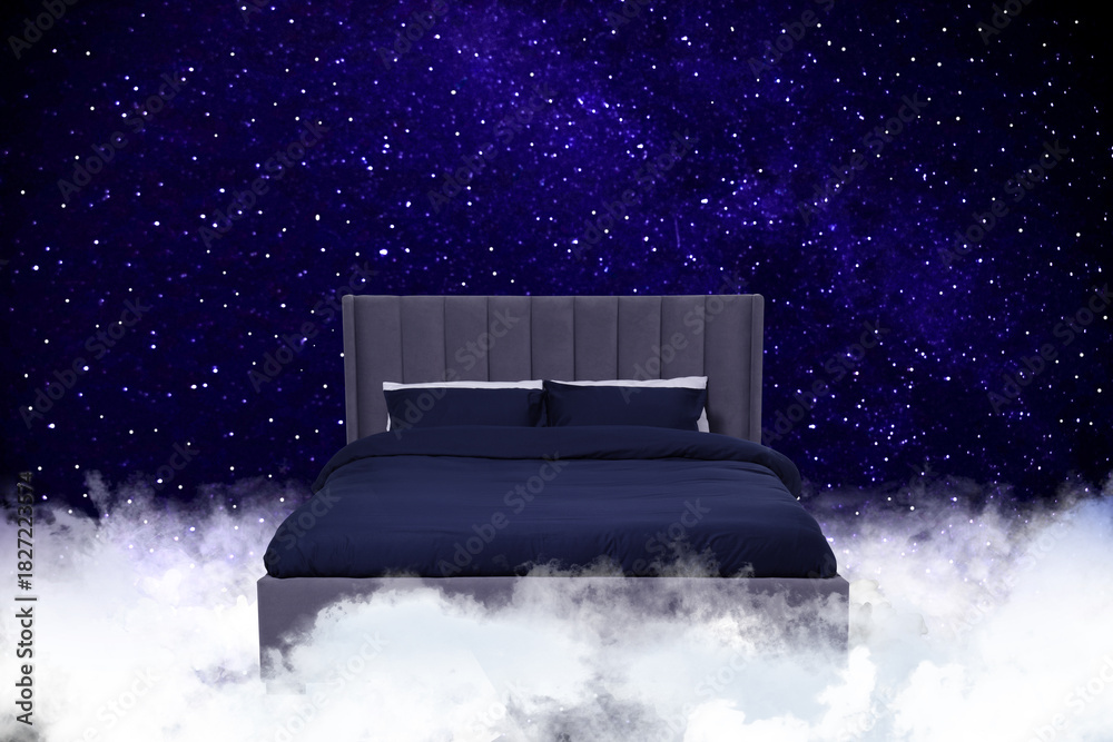 Fototapeta premium Large bed on fluffy clouds in starry night sky