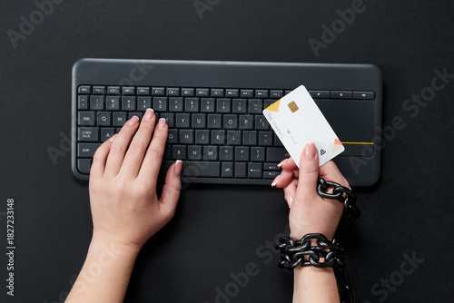 Bild auf Leinwand Woman with metal chain holding credit card over keyboard, online shopping addict