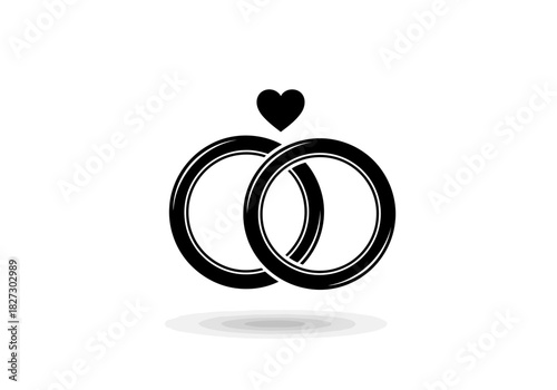Black and white icon of two interlocking wedding rings with a small heart above them