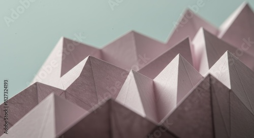 Delicate pink paper folded into sharp, geometric peaks, creating a textured abstract pattern